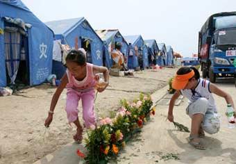 Two girls clean the ground after putting on flower decoration at the Mianzhu Sports Center, which was turned into a temporary shelter, in Mianzhu city, southwest China's Sichuan province, June 2, 2008. Volunteers from Guizhou province transported flowers to the quake-hit Mianzhu city recently to decorate the square and temporary shelter.(Xinhua/Qi Zhenlin)