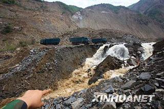 Water from Tangjiashan "quake lake" flows into a man-made sluice channel in Mianyang City, Southwest China's Sichuan Province, June 7, 2008. The long-awaited drainage of China's Tangjiashan "quake lake" started on Saturday morning, as its water flowed into a man-made sluice channel.(Xinhua Photo)