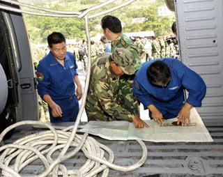 Rescue workers locate target place on a map before they set off to the spot where remains of the missing Chinese helicopter were found at Yingxiu Township, Wenchuan County in Southwest China's Sichuan Province on June 10, 2008. Searchers found debris of the downed Mi-171 helicopter at 10:55 am Tuesday in the bushes northwest of Yingxiu Township. A crew of five military personnel and 14 quake victims were all found dead.  (Xinhua Photo)