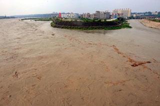 The drainage water of Tangjiashan quake-formed lake passes Mianyang City, southwest China's Sichuan Province, June 10, 2008. The crest of the flood from Tangjiashan quake-formed lake passed safely by downstream Mianyang City on Tuesday afternoon. (Xinhua Photo)