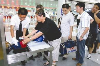 Passengers receive security check at a subway station in downtown Beijing, China,June 29, 2008.