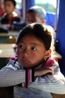 Yang Xue, a 7-year-old girl, listens at a class in a tent school in Shidaguan Township of Maoxian County, southwest China's Sichuan Province, June 10.(Xinhua Photo)