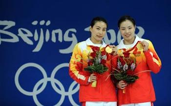 Chinese divers Guo Jingjing (L) and Wu Minxia pose for picture during the awarding ceremony for women's synchro 3m springboard at the Beijing 2008 Olympic Games in the National Aquatics Center, also known as the Water Cube in Beijing, China, Aug. 10, 2008. Guo and Wu claimed the title in the event with a score of 343.50 poionts. (Xinhua/Zhao Peng)