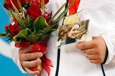 Matthias Steiner of Germany holds a photo of his late wife Susann as he poses with his gold medal in the men's +105kg Group A weightlifting competition at the Beijing 2008 Olympic Games August 19, 2008. [Agencies]