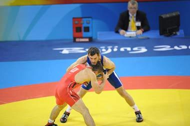 Buvaysa Saytiev of Russia (in blue) fights against Soslan Tigiev of Uzbekistan (Photo credit: Li Gang/Xinhua)