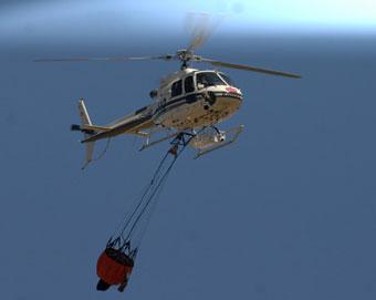 A fire helicopter tries to put out fire as a Spanish plane catches fire at Madrid's Barajas airport, Aug. 20, 2008. The Spanair MD-80 jet plane with some 160 people onboard veered off the runway and caught fire while taking off here Wednesday, killing 147 people, injuring over 20, according to the rescuer.(Xinhua Photo)