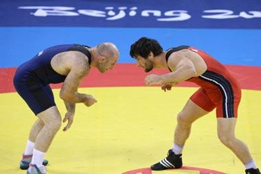 Yusup Abdusalomov (red) of Tajikistan fights against Revazi Mindorashvili of Georgia during their men's freestyle 84kg gold medal match of the Beijing 2008 Olympic Games Wrestling event in Beijing, China, Aug. 21, 2008. Revazi Mindorashvili beat Yusup Abdusalomov and grabbed the gold.(Xinhua/Lu Mingxiang)