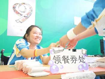 Dong Ming currently spends her days distributing meal coupons for volunteers working at the Water Cube. [Photo: CRIENGLISH.com]