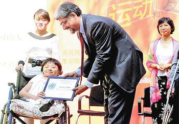 United Nations Resident Coordinator in China Khalid Malik presents a certificate to Yu Haibo, founder of the Changchun Xinyu Volunteer Association, in Beijing Monday. The association focuses on helping the disabled.