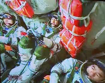 The video grab taken on Sept. 25, 2008 at the Beijing Space Command and Control Center in Beijing, China, shows Chinese taikonauts in the return module of the Shenzhou-7 spacecraft.(Xinhua Photo)