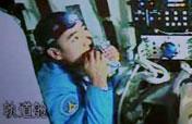 Chinese taikonaut tries bite on his food in Shenzhou-7