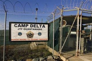 In this June 6, 2008 file photo, reviewed by the U.S. Military, a guard stands at a gate at the Camp Delta detention compound, which has housed foreign prisoners since 2002, at Guantanamo Bay U.S. Naval Base in Cuba.(AP Photo/Brennan Linsley, File)