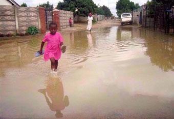 A young girl walks through sewage water in the Harare township of Dzivaresekwa. Former US president Jimmy Carter has accused Zimbabwe's government of being 