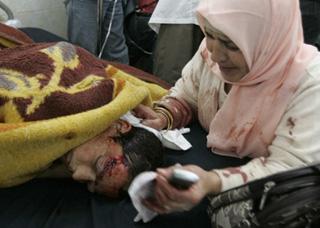 A woman cries beside her son who was wounded in a bomb attack, in a hospital in Kirkuk, 250 km (155 miles) north of Baghdad December 11, 2008. [Agencies]