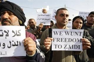 Iraqis hold up a posters calling for the release of an Iraqi journalist who hurled his shoes at visiting US President George W. Bush. (AFP/Ahmad al-Rubaye) 