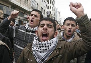 Palestinians protest against Israeli strikes in Gaza in the West Bank town of Hebron, Saturday, Dec. 27, 2008. Israeli warplanes retaliating for rocket fire from Gaza pounded dozens of security compounds across the Hamas-ruled territory in unprecedented waves of air strikes Saturday, killing at least 200 and wounding nearly 400 in the bloodiest day in Gaza in decades.(AP Photo/Nasser Shiyoukhi) 