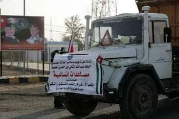 One of the trucks carrying humanitarian aid for the Gaza Strip drives past a Jordanian policeman at the King Hussein Bridge crossing December 29, 2008.REUTERS/Muhammad Hamed