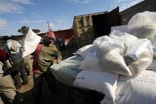 A Palestinian carries sacks of flour at the United Nations Relief and Works Agency (UNRWA) centre at the Rafah refugee camp in the Gaza Strip on January 3.  (AFP/File/Said Khatib)