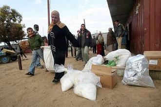 Palestinians receive food aid from the United Nations Relief and Works Agency (UNRWA) at the refugee camp of Rafah in the southern Gaza Strip on the border with Egypt.(AFP/Said Khatib)