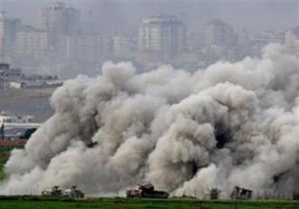 Armoured Israeli military vehicles move near plumes of smoke in the northern Gaza Strip January 16, 2009. (Ronen Zvulun/Reuters)