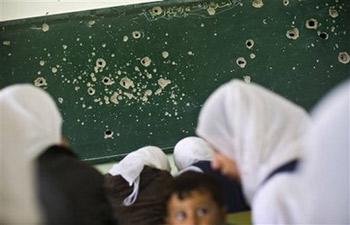 Palestinian students study in a classroom damaged in an Israeli army strike earlier this month, in Bureij camp in the central Gaza Strip, Thursday Jan. 29, 2009. 