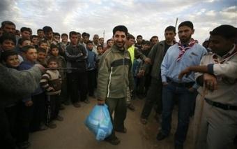 Palestinian Jumma Dardona, 34, center, receives humanitarian food in a makeshift camp in eastern Jebaliya, northern Gaza strip, Wednesday, Jan. 28, 2009.(AP Photo/Anja Niedringhaus) 