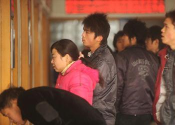 Migrant workers look for job information at the human resource market in Hangzhou, capital of east China's Zhejiang province, Jan. 31, 2009. A propose signed by 200 local enterprises at the beginning of the New Year calls for no layoffs and no salary cut in 2009 that encouraged the migrant workers to come back to towns after the Spring Festival holidays. (Xinhua/Tan Jin)