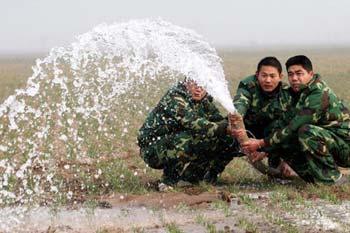 People irrigate the wheat field at Xiaolu Village in Yuzhou, a city in central China's Henan Province, on Feb. 4, 2009. Henan, China's major grain producer, issued a red alert for drought on Jan. 29. The provincial meteorological bureau said the drought is the worst since 1951. The drought has affected 63 percent of the province's 5.26 million hectares of wheat. (Xinhua/Niu Shupei)