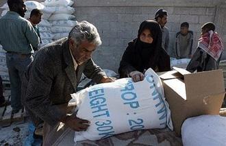 A Palestinian man carries a bag of food aid from the United Nations Relief and Works Agency (UNRWA) at the refugee camp of Rafah, January 2008.(AFP/File/Said Khatib)