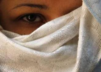 A woman who was abused by her husband covers her face, so as not to be identified by her family, at the Sisterhood Is Global Institute office in Amman March 5, 2009, ahead of the International Day for the Elimination of Violence against Women. REUTERS/Ali Jarekji