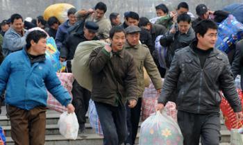 Migrant workers are seen carrying baggages in this photo taken on February 27, 2009, in Zhengzhou, central China's Henan province. [Xinhua] 