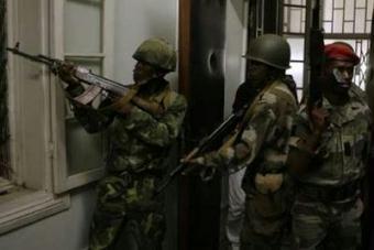 Soldiers take aim after two tanks backed by troops forced their way into a presidential palace in Antananarivo March 16, 2009. Tanks successfully forced their way into the presidential palace in the centre of Madagascar's capital on Monday, but the president was not in the building.REUTERS/Siphiwe Sibeko(MADAGASCAR POLITICS CONFLICT)