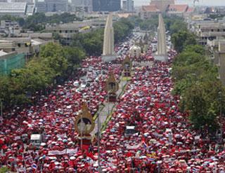 Supporters of former Thai Prime Minister Thaksin Shinawatra walk past the Democracy monument during a protest march to the Government House in Bangkok March 26, 2009. About 10,000 red-shirted protesters began their march from Sanam Luang to the Government House on Thursday, a local newspaper reported. (Xinhua/Reuters Photo)