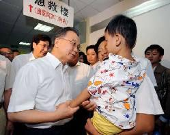 Chinese Premier Wen Jiabao (L, front) talks to a child at Beijing Children's Hospital in Beijing on September 21, 2008.[Xinhua/file]