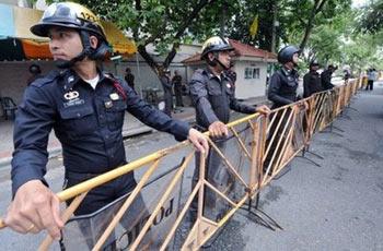 Policemen stand guard ahead of a protest march by supporters of Thailand's ousted premier Thaksin Shinawatra in Bangkok. Anti-government protesters have trapped Thai premier Abhisit Vejjajiva inside a beach hotel and attacked his motorcade as the kingdom's political turmoil boiled over into violence.(AFP/Pornchai Kittiwongsakul) 