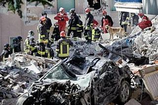 Rescuers search in the remains of a building which collapsed the day before during a violent earthquake in the Abruzzo capital L'Aquila. Earthquake aftershocks rocked the Italian city of L'Aquila on Tuesday, raining fresh lumps of debris as rescuers pulled out more survivors and the death toll passed 200.(AFP/Vincenzo Pinto)