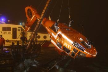 The wreckage of a helicopter from China's Antarctic exploration ship Xuelong is hoisted up almost a nautical mile from its crash site in the East China Sea off Shanghai, April 12, 2009. (Xinhua)