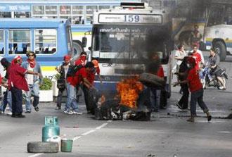 Supporters of ousted Thai prime minister Thaksin Shinawatra burn tyres as they block a main road in Bangkok April 13, 2009.REUTERS/Vivek Prakash