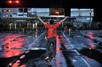 A Thai supporter of exiled Prime Minister Thaksin Shinawatra faces the Thai army at Ding Daeng intersection in the early morning, in Bangkok. Thousands of Thai anti-government protesters clashed with armed soldiers and Bangkok residents Monday, leaving two dead and 113 injured in street battles that raged across the capital.(AFP/Nicolas Asfouri)