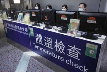 Staff members check the temperature of passengers with the help of machines at Hong Kong International Airport in Hong Kong, south China, April 27, 2009. Hong Kong Special Administrative Region has taken measures to contain the possible spread of swine flu. (Xinhua Photo)