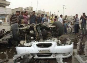 Residents gather at a burnt vehicle at the site of a bomb attack in Baghdad's Sadr City April 29, 2009. The toll from twin car bomb blasts on Wednesday in a busy market in Baghdad jumped to 41 killed and 68 wounded, Iraqi police said.REUTERS/Kahtan al-Mesiary 