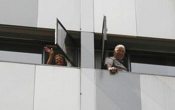 One of the hotel guests wave to journalists on the ground as approximately 200 guests and 100 staff are ordered to stay inside a hotel in Hong Kong May 3, 2009.[Agencies]