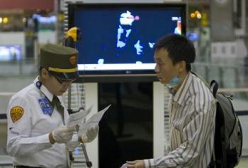 A Chinese citizen waits for boarding at Benito Juarez international airport in Mexico City, capital of Mexico, May 5, 2009. A total of 79 Chinese citizens left Mexico City early Tuesday aboard a chartered flight sent by the Chinese government. The plane took off from Mexico City, heading towards Tijuana, northern Mexico, to lift 20 more Chinese before returning to China. (Xinhua/David De la Paz)