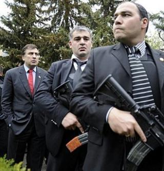 Georgian President Mikheil Saakashvili (L) guarded by bodyguards at the Mukhrovani military base some 10km outside of Tbilisi on May 05. NATO on Wednesday began controversial military exercises in Georgia a day after the ex-Soviet republic said it had put down a military rebellion that had Russia's backing.(AFP/File/Irakli Gedenidze)