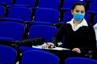 A Mexican student attends her class wearing a surgical mask at the Faculty of Medicine in the Mexican Autonomous University in Mexico City. Global health chiefs warned against complacency over swine flu Thursday saying one in three people may be infected worldwide if there is a pandemic, as life in Mexico got back to normal.(AFP/Luis Acosta)