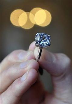 A Sotheby's employee displays a rare vivid blue diamond ring weighing 7.03 carats, during a preview at Sotheby's in Geneva, Switzerland, Wednesday, May 6, 2009.(AP Photo/Keystone, Martial Trezzini)