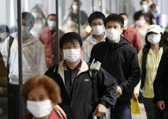 Passengers from the U.S. wearing face masks arrive at Narita international airport in Narita May 9, 2009.REUTERS/Issei Kato