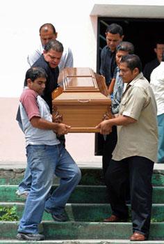 Costa Rica's health minister confirmed the death of a 53-year-old patient with swine flu on Saturday, the first death from the pandemic outside of a North American nation. The Photo shows relatives of the dead patient carry his coffin in front of a church in Coronado, Costa Rica, May 9, 2009. (Xinhua/AFP Photo)