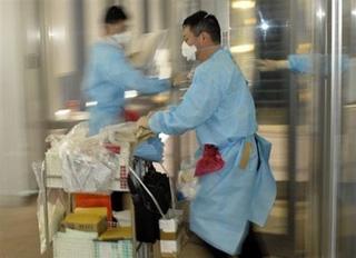 Japanese quarantine officials inspect a plane that arrived from Chicago at Narita airport in Tokyo. (AFP/Toshifumi Kitamura)