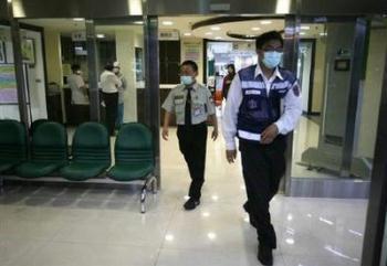 Security guards walk out of the entrance of the Taipei City Heping Hospital May 11, 2009. China quarantined more than 130 of the 150 passengers aboard a flight that carried a Chinese man who was the mainland's first suspected case of H1N1 flu, the Xinhua news agency said on Monday.